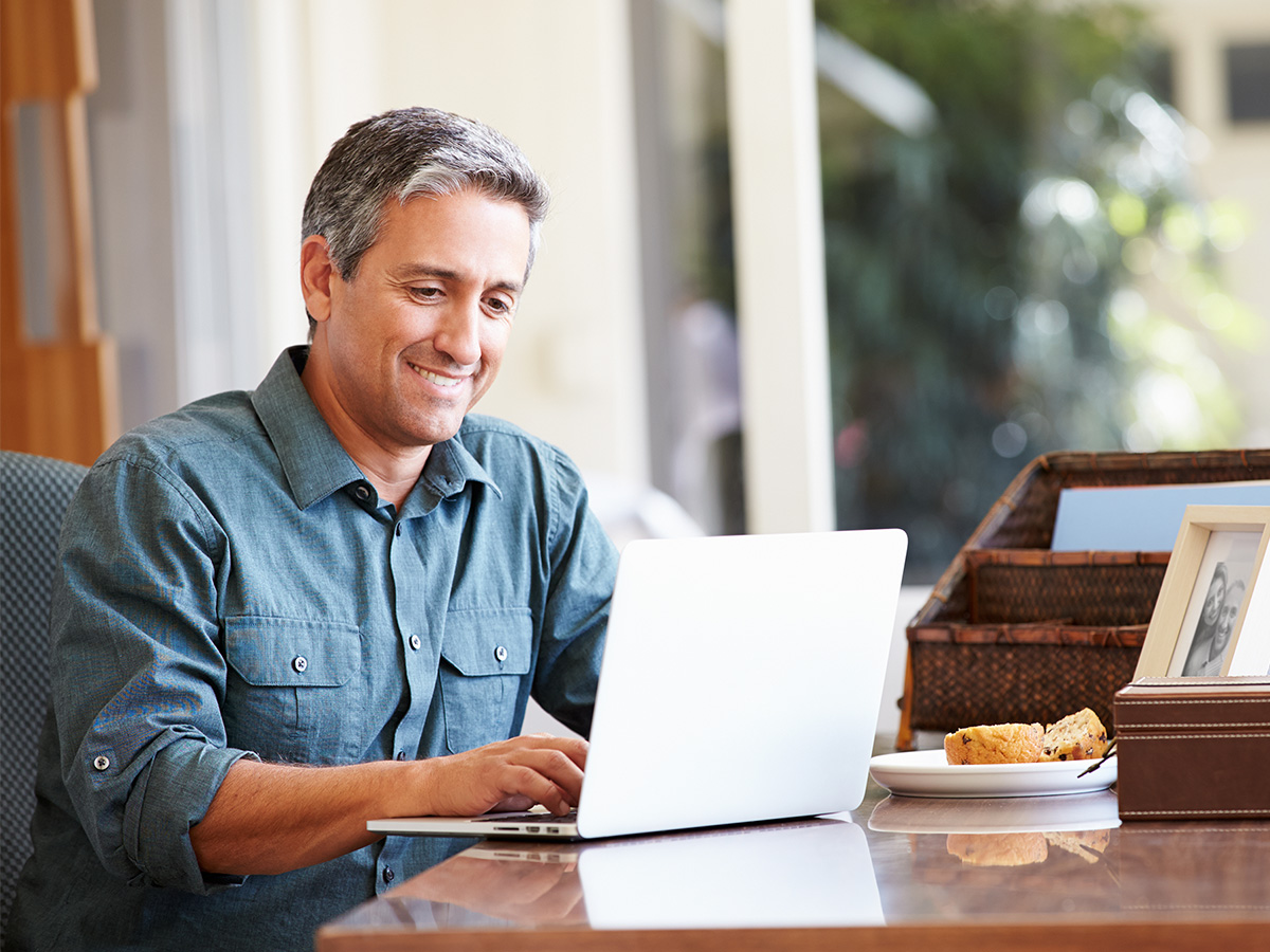 A man smiling at his computer