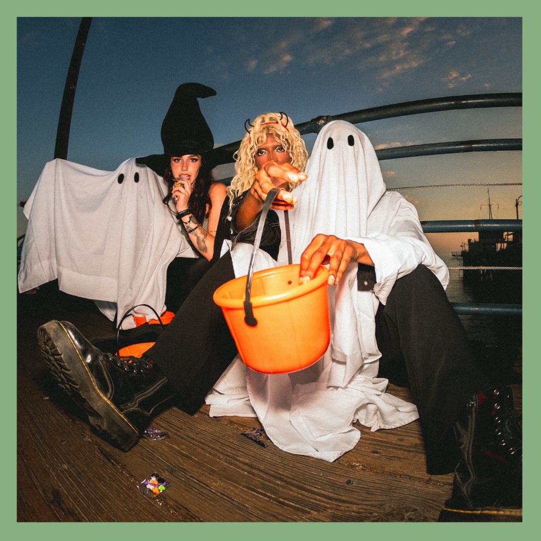 People in Halloween costumes holding candy bucket.